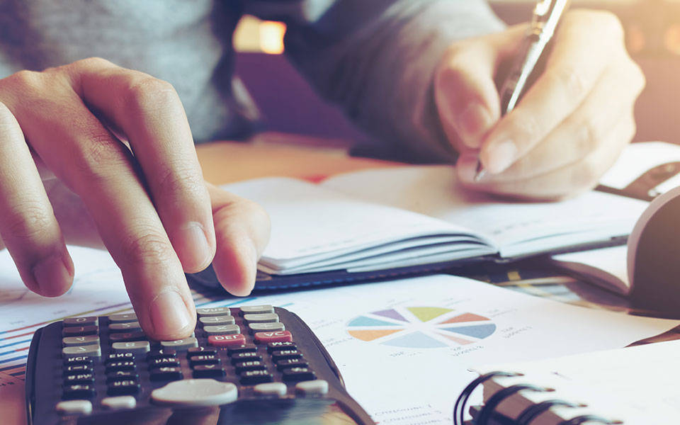 Man using calculator and bookkeeping Man using calculator and bookkeeping